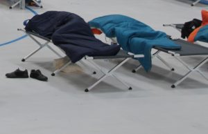 Deux lits de camps recouverts de devets sur la patinoire de Cergy