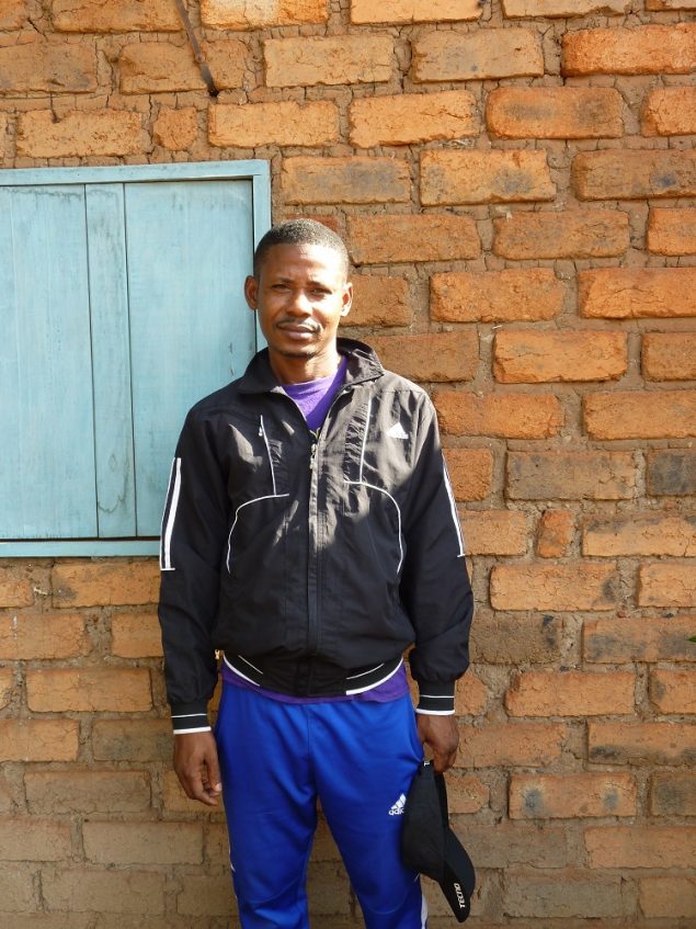 Hamidou pose devant le mur de sa maison dans la zone PK5 de Bangui