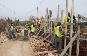 Des ouvriers construisent un mur près de l'école Jaloud