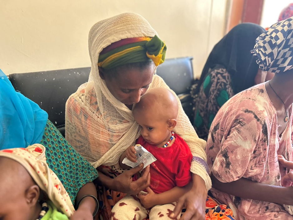 Une mère nourrissant son enfant avec des aliments thérapeutiques prêts à l'emploi (ATP) au centre de santé d'Abala © Première Urgence Internationale
